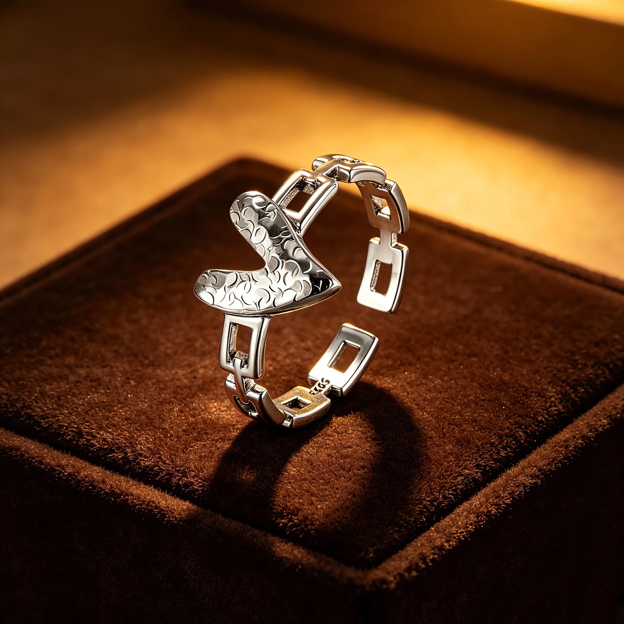 This is an adjustable open ring crafted from S925 sterling silver. It features a modern chain-link band paired with a textured heart-shaped centerpiece, boasting a "crushed ice" finish that delivers a sparkling, dimensional look. The polished silver tone lends a sleek, contemporary vibe to this versatile piece.