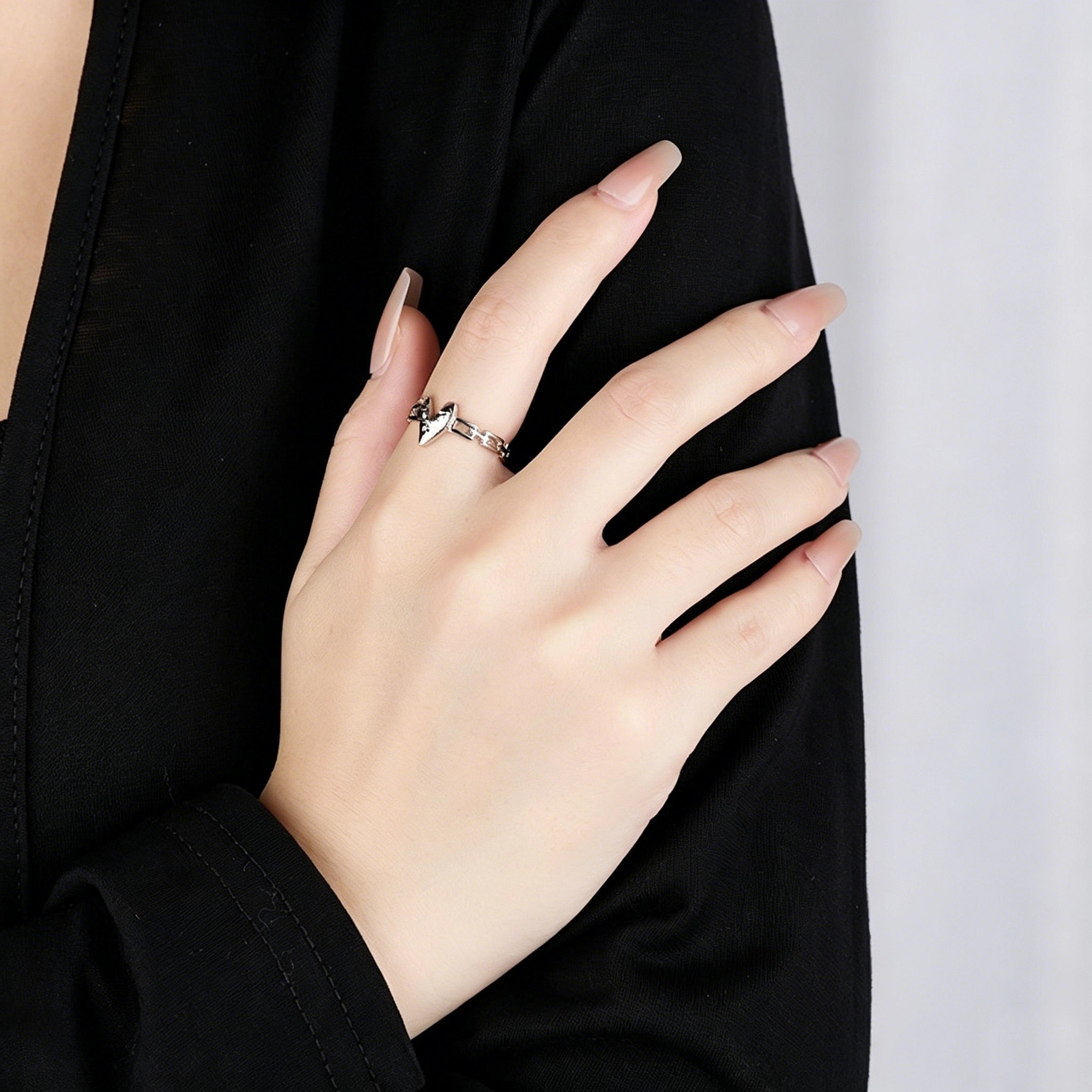 This is an adjustable open ring crafted from S925 sterling silver. It features a modern chain-link band paired with a textured heart-shaped centerpiece, boasting a "crushed ice" finish that delivers a sparkling, dimensional look. The polished silver tone lends a sleek, contemporary vibe to this versatile piece.
