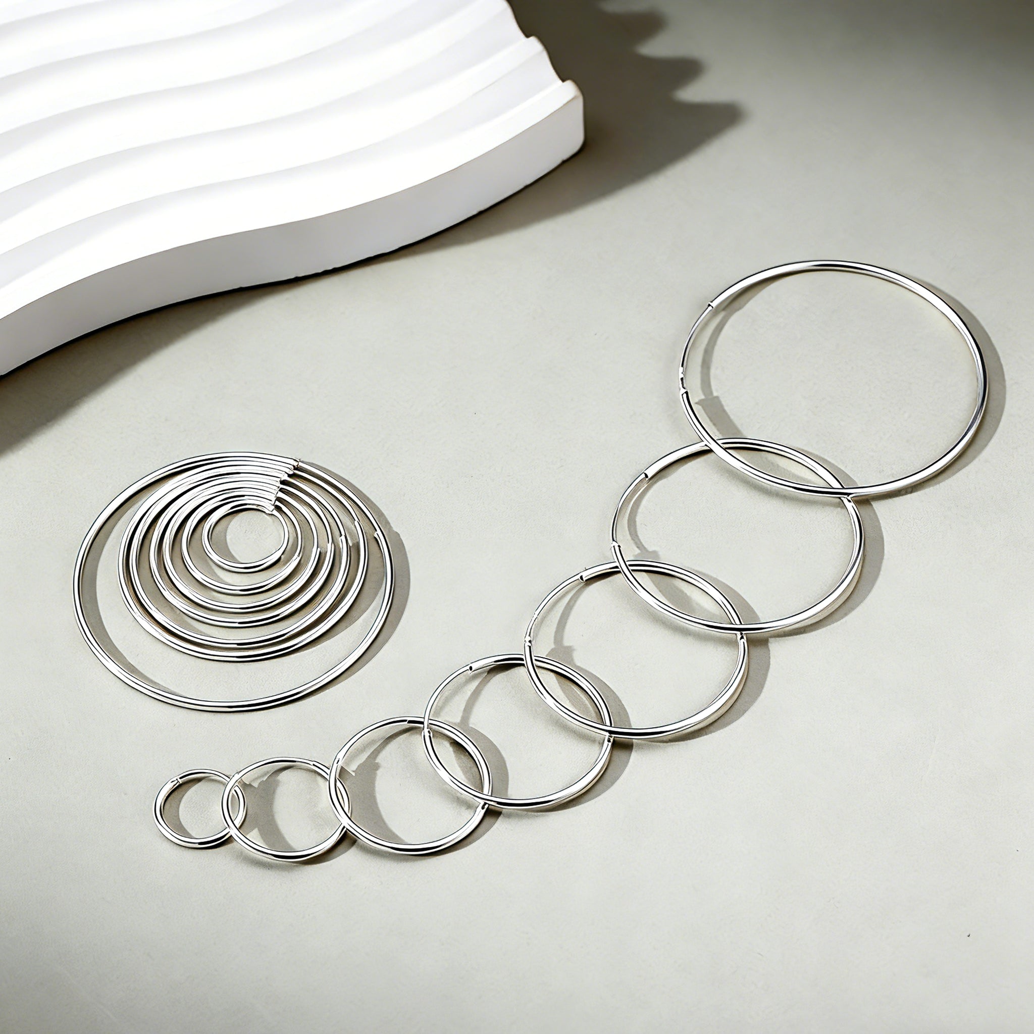 These S925 sterling silver hoop earrings feature a sleek, polished circular design with a smooth, reflective finish. They showcase a classic minimalist silhouette with a seamless, slender wire construction that exudes understated elegance. The polished surface catches light beautifully, highlighting their timeless and versatile appeal.
