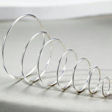 These S925 sterling silver hoop earrings feature a sleek, polished circular design with a smooth, reflective finish. They showcase a classic minimalist silhouette with a seamless, slender wire construction that exudes understated elegance. The polished surface catches light beautifully, highlighting their timeless and versatile appeal.