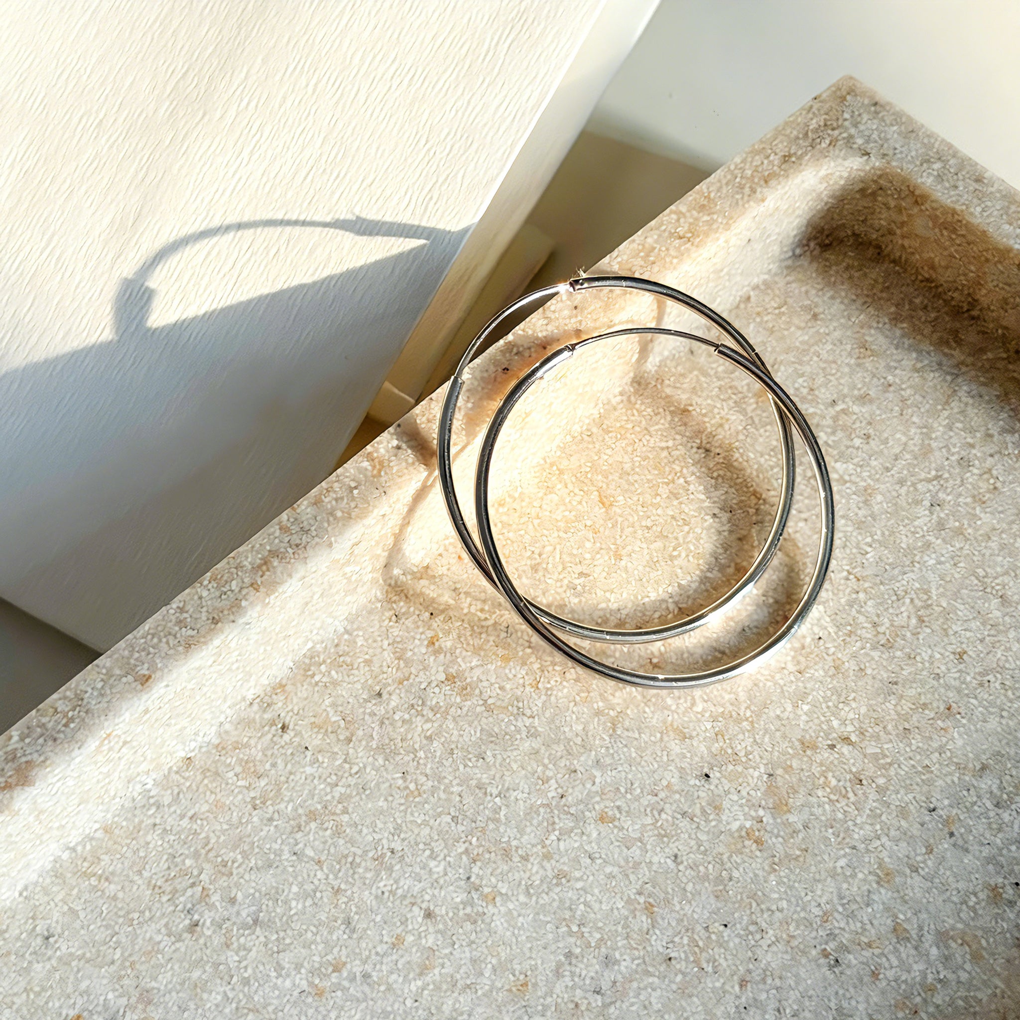 These S925 sterling silver hoop earrings feature a sleek, polished circular design with a smooth, reflective finish. They showcase a classic minimalist silhouette with a seamless, slender wire construction that exudes understated elegance. The polished surface catches light beautifully, highlighting their timeless and versatile appeal.
