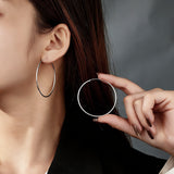 These S925 sterling silver hoop earrings feature a sleek, polished circular design with a smooth, reflective finish. They showcase a classic minimalist silhouette with a seamless, slender wire construction that exudes understated elegance. The polished surface catches light beautifully, highlighting their timeless and versatile appeal.