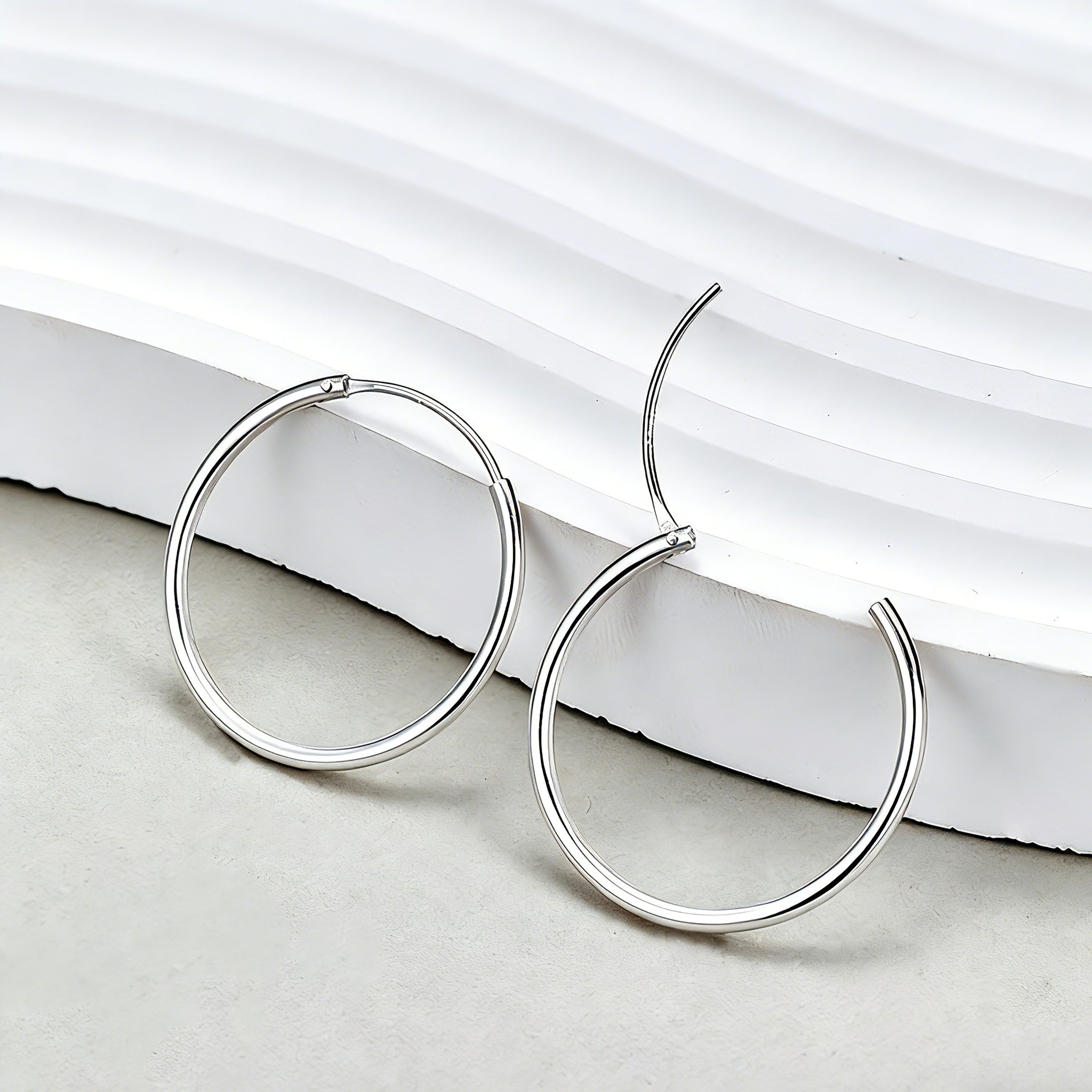 These S925 sterling silver hoop earrings feature a sleek, polished circular design with a smooth, reflective finish. They showcase a classic minimalist silhouette with a seamless, slender wire construction that exudes understated elegance. The polished surface catches light beautifully, highlighting their timeless and versatile appeal.