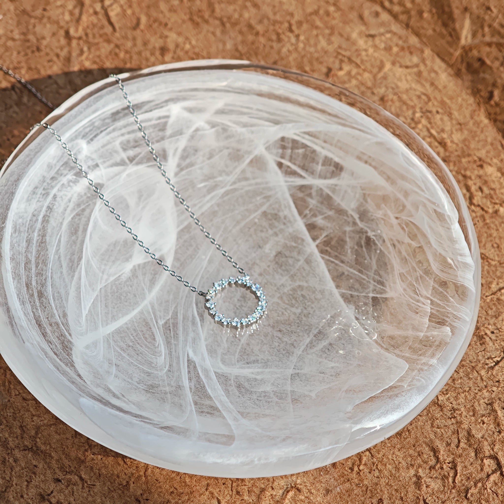 This S925 silver necklace features a delicate circular pendant encrusted with shimmering moissanite stones, forming an elegant open-circle silhouette. The slender silver chain complements the pendant perfectly, lending a refined and timeless charm to the piece. Its minimalist yet sparkling design makes it a versatile accessory for various occasions.