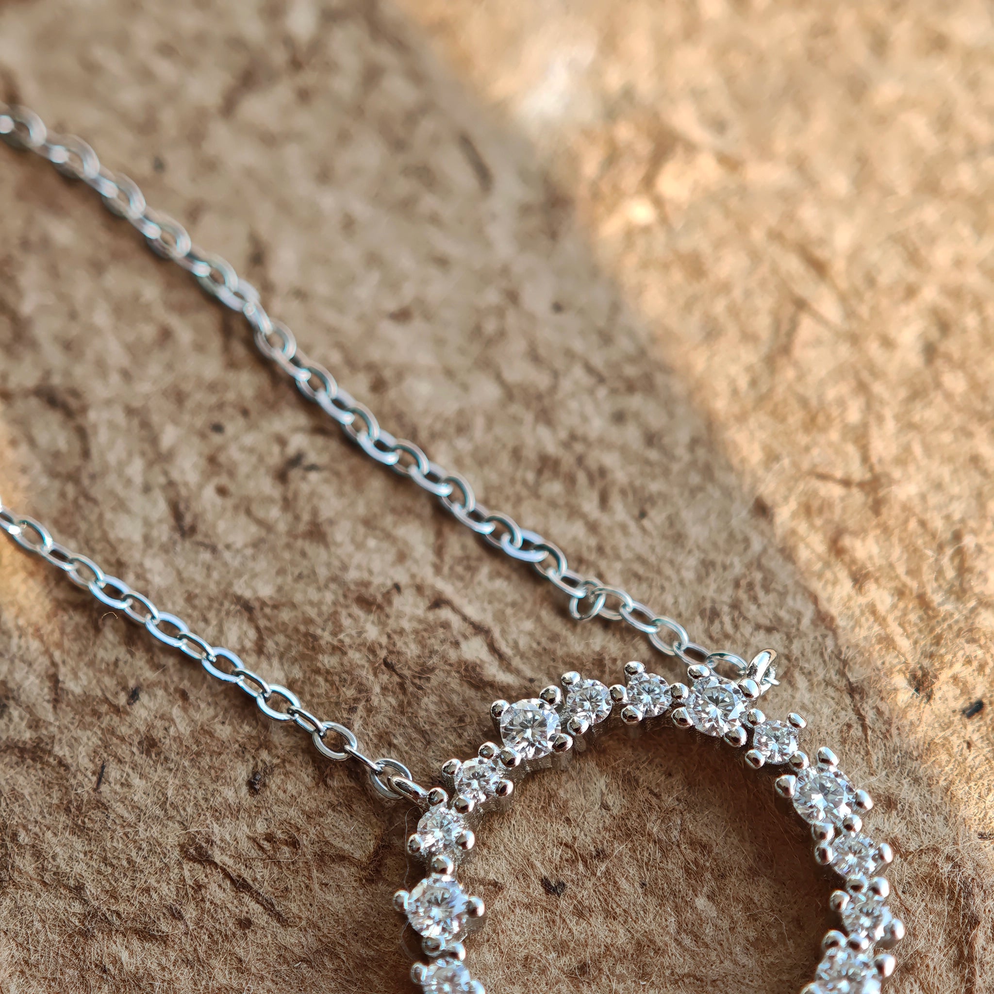 This S925 silver necklace features a delicate circular pendant encrusted with shimmering moissanite stones, forming an elegant open-circle silhouette. The slender silver chain complements the pendant perfectly, lending a refined and timeless charm to the piece. Its minimalist yet sparkling design makes it a versatile accessory for various occasions.