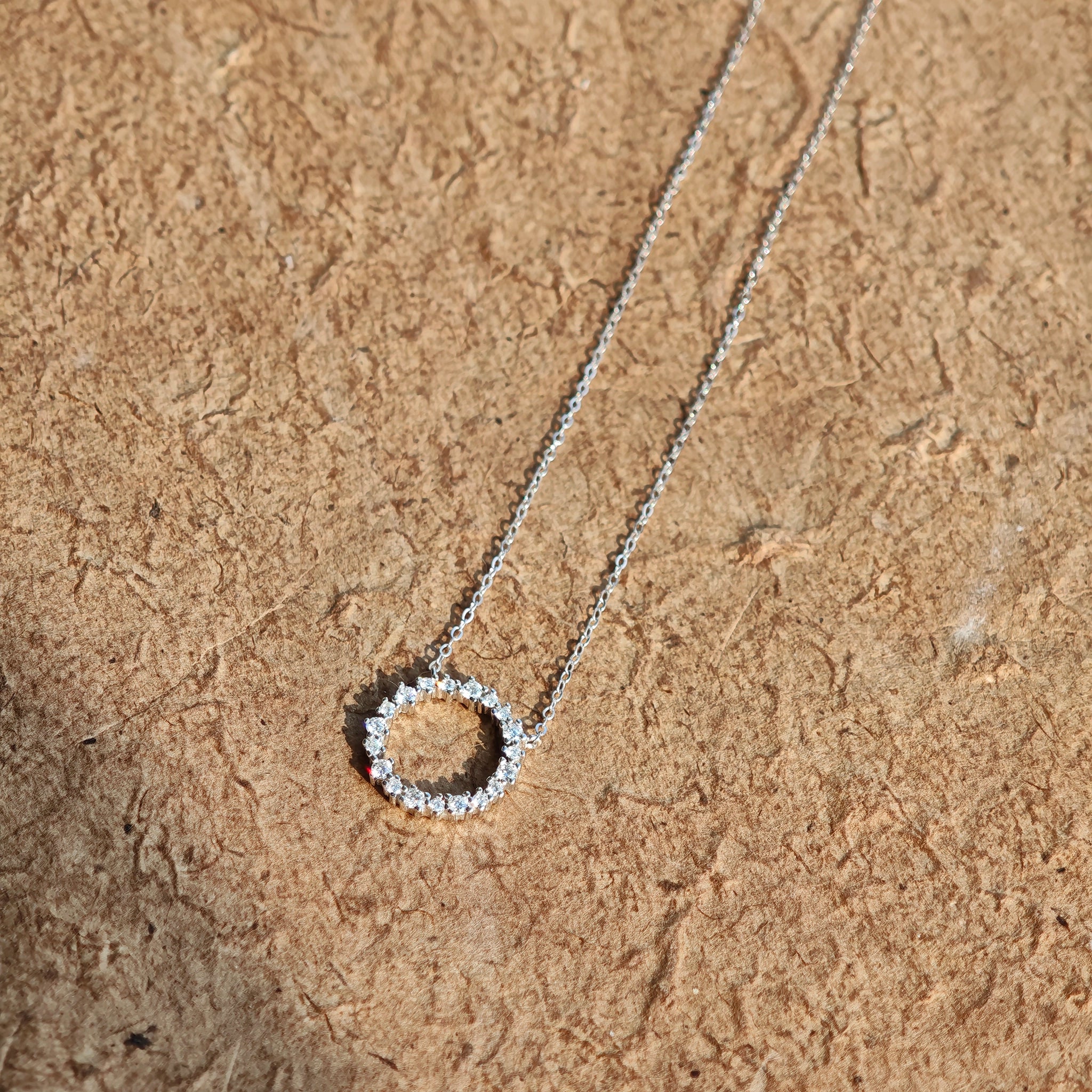 This S925 silver necklace features a delicate circular pendant encrusted with shimmering moissanite stones, forming an elegant open-circle silhouette. The slender silver chain complements the pendant perfectly, lending a refined and timeless charm to the piece. Its minimalist yet sparkling design makes it a versatile accessory for various occasions.