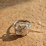 This adjustable S925 sterling silver ring features a striking baroque pearl at its center, set within an organic, flowing silver frame that wraps around the irregular, lustrous gemstone. The open, sculptural metalwork creates a modern, artistic silhouette, showcasing the pearl's natural, one-of-a-kind texture and soft iridescence. The sleek, polished silver band complements the unique pearl, making it a standout piece with a contemporary, bohemian aesthetic.