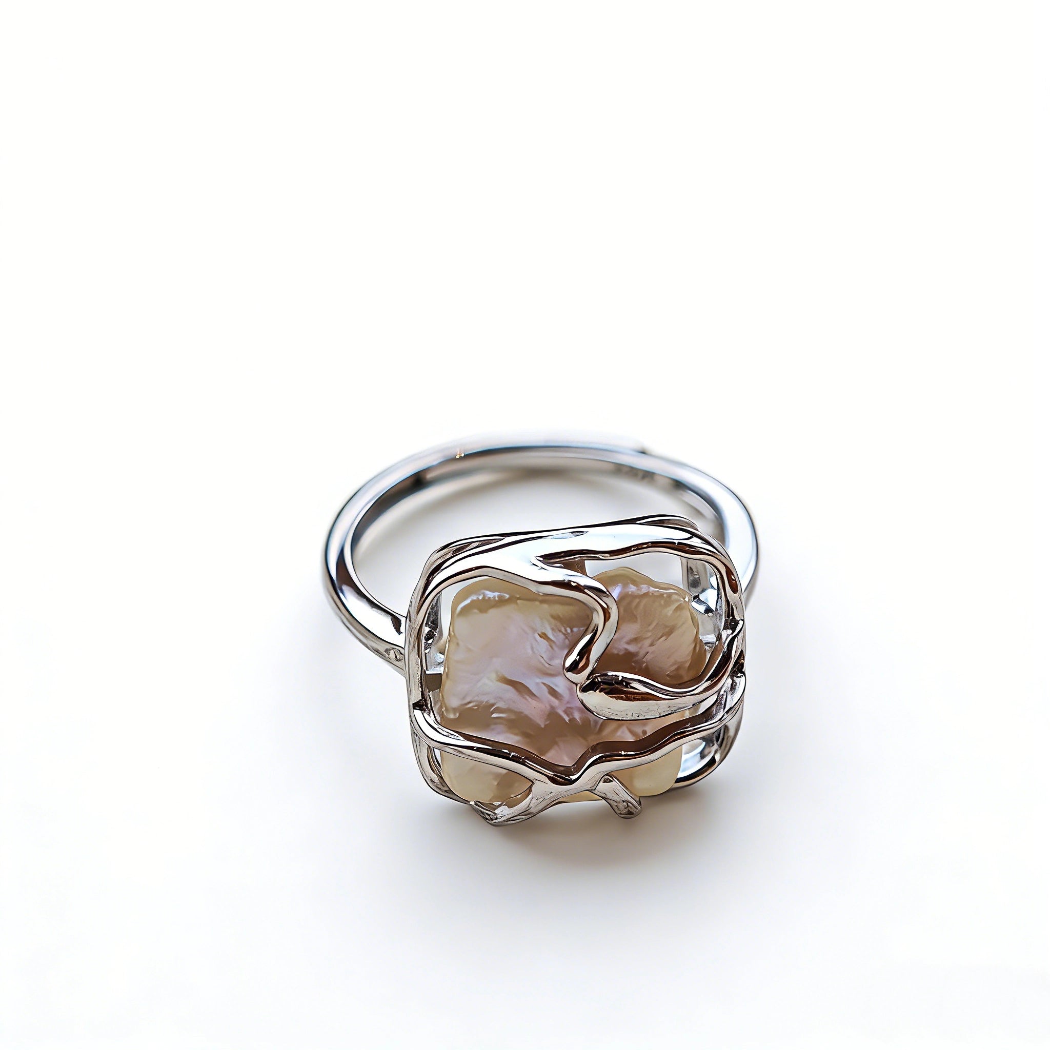This adjustable S925 sterling silver ring features a striking baroque pearl at its center, set within an organic, flowing silver frame that wraps around the irregular, lustrous gemstone. The open, sculptural metalwork creates a modern, artistic silhouette, showcasing the pearl's natural, one-of-a-kind texture and soft iridescence. The sleek, polished silver band complements the unique pearl, making it a standout piece with a contemporary, bohemian aesthetic.
