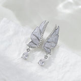 These S925 sterling silver earrings are designed in the shape of delicate butterfly wings, with a resin craft on the wing surfaces and a row of shimmering cubic zirconia along the edges. A teardrop-cut clear gemstone dangles elegantly from the bottom of each wing, adding a graceful and sparkling touch to the overall design.