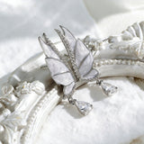 These S925 sterling silver earrings are designed in the shape of delicate butterfly wings, with a resin craft on the wing surfaces and a row of shimmering cubic zirconia along the edges. A teardrop-cut clear gemstone dangles elegantly from the bottom of each wing, adding a graceful and sparkling touch to the overall design.