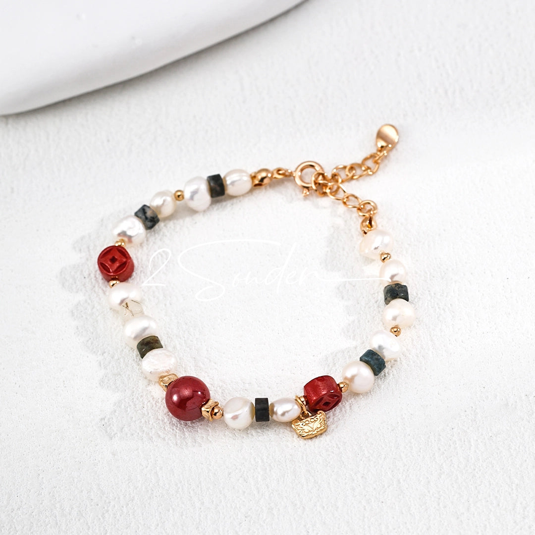 This is a bracelet made of S925 sterling silver, red cinnabars, green moss agates and natural white pearls. It's 16cm long with a 3cm extended chain. It comes with a lobster clasp which is easy to be used.