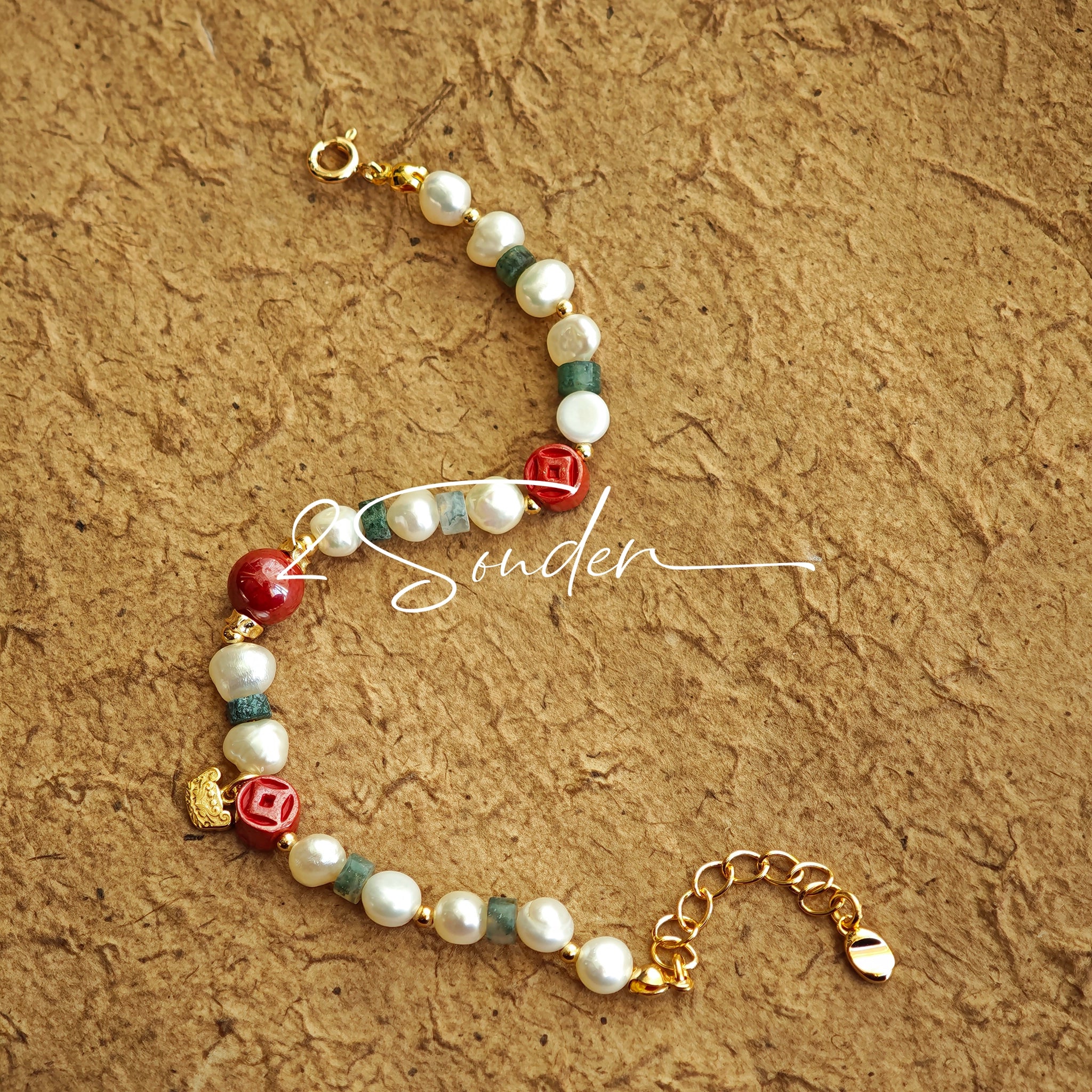 This is a bracelet made of S925 sterling silver, red cinnabars, green moss agates and natural white pearls. It's 16cm long with a 3cm extended chain. It comes with a lobster clasp which is easy to be used.
