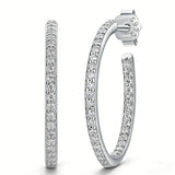 These 925 sterling silver hoop earrings are elegantly lined with sparkling moissanite stones along their entire length, creating a continuous, luminous sheen. The sleek, open-hoop design is secured with a classic butterfly back, blending timeless elegance with modern sophistication. The polished silver finish enhances the brilliance of the moissanite, making them a versatile accessory for both everyday wear and special occasions.