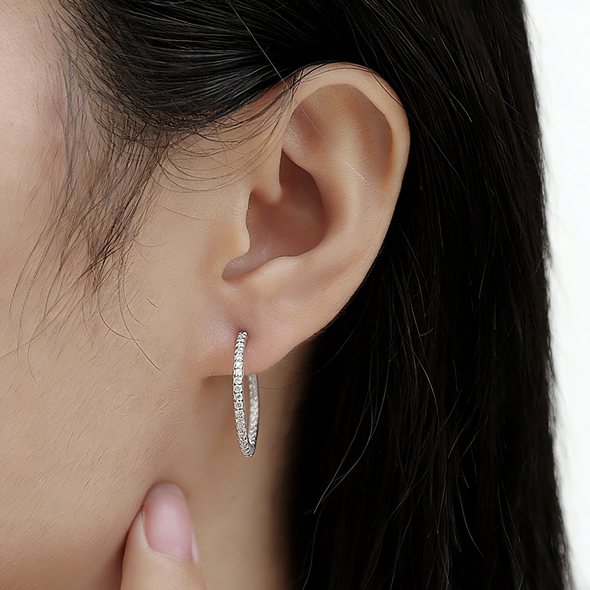 These 925 sterling silver hoop earrings are elegantly lined with sparkling moissanite stones along their entire length, creating a continuous, luminous sheen. The sleek, open-hoop design is secured with a classic butterfly back, blending timeless elegance with modern sophistication. The polished silver finish enhances the brilliance of the moissanite, making them a versatile accessory for both everyday wear and special occasions.