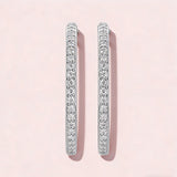 These 925 sterling silver hoop earrings are elegantly lined with sparkling moissanite stones along their entire length, creating a continuous, luminous sheen. The sleek, open-hoop design is secured with a classic butterfly back, blending timeless elegance with modern sophistication. The polished silver finish enhances the brilliance of the moissanite, making them a versatile accessory for both everyday wear and special occasions.