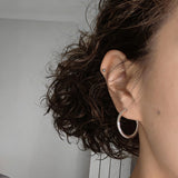 These 925 sterling silver hoop earrings are elegantly lined with sparkling moissanite stones along their entire length, creating a continuous, luminous sheen. The sleek, open-hoop design is secured with a classic butterfly back, blending timeless elegance with modern sophistication. The polished silver finish enhances the brilliance of the moissanite, making them a versatile accessory for both everyday wear and special occasions.