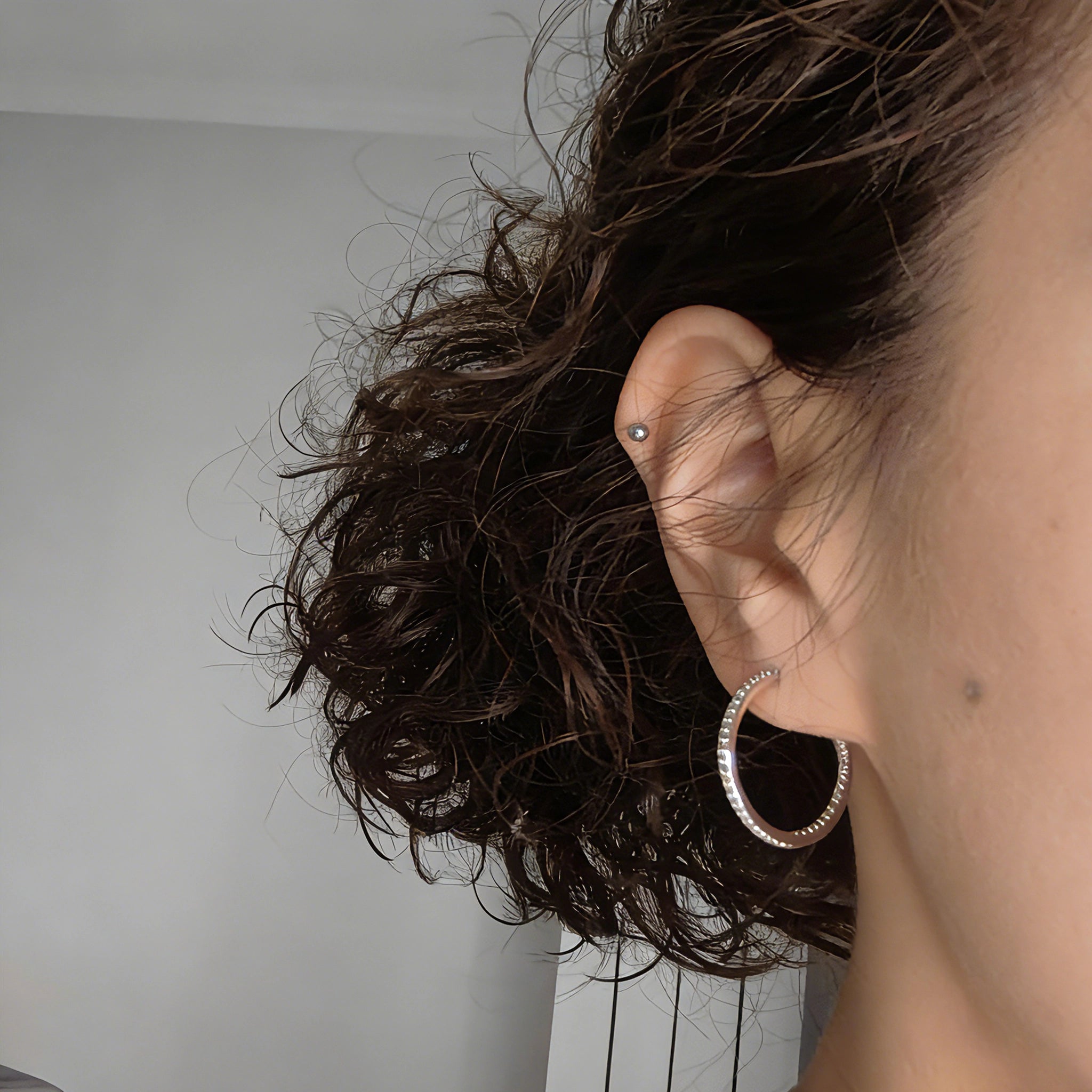These 925 sterling silver hoop earrings are elegantly lined with sparkling moissanite stones along their entire length, creating a continuous, luminous sheen. The sleek, open-hoop design is secured with a classic butterfly back, blending timeless elegance with modern sophistication. The polished silver finish enhances the brilliance of the moissanite, making them a versatile accessory for both everyday wear and special occasions.