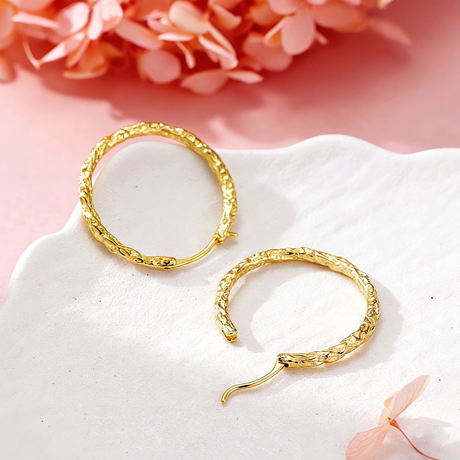 These S925 sterling silver hoop earrings feature a textured, molten lava-like finish in a warm gold tone. The organic, uneven surface creates a rugged, handcrafted appearance, while the classic oval hoop shape adds a timeless, elegant touch to the design. The secure post-back closure ensures comfortable all-day wear.