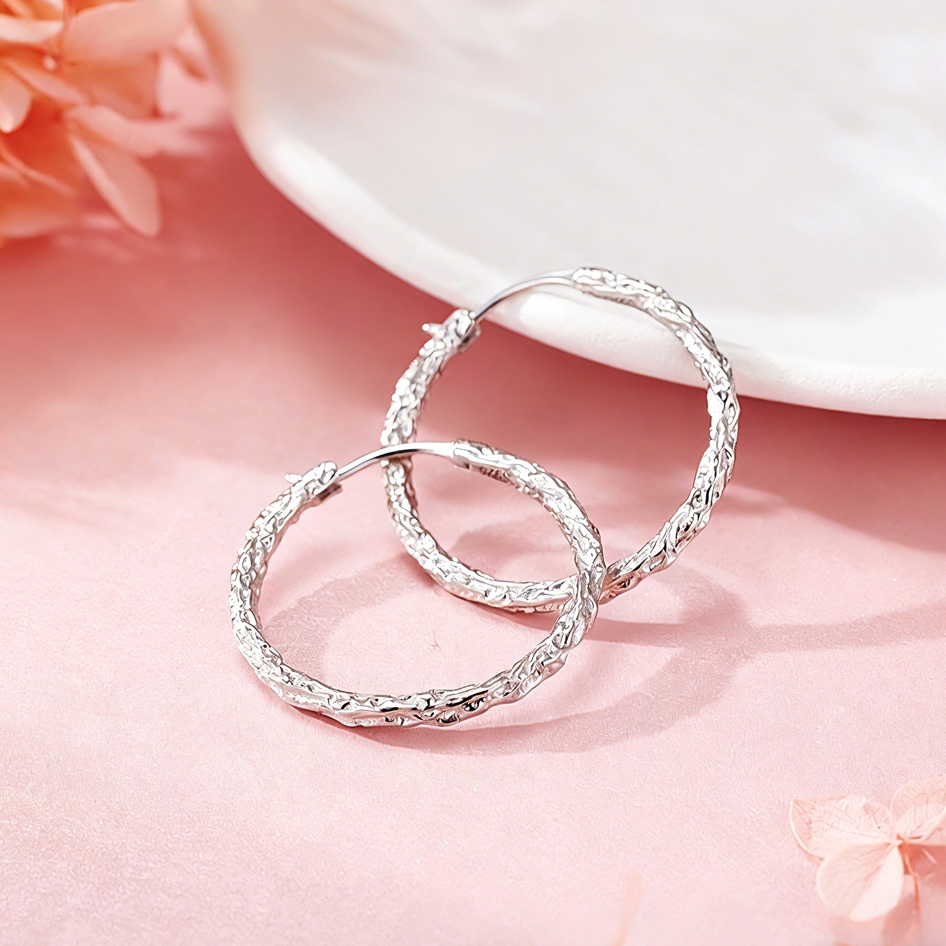 These S925 sterling silver hoop earrings feature a textured, molten lava-like finish in a warm gold tone. The organic, uneven surface creates a rugged, handcrafted appearance, while the classic oval hoop shape adds a timeless, elegant touch to the design. The secure post-back closure ensures comfortable all-day wear.