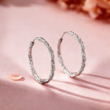 These S925 sterling silver hoop earrings feature a textured, molten lava-like finish in a warm gold tone. The organic, uneven surface creates a rugged, handcrafted appearance, while the classic oval hoop shape adds a timeless, elegant touch to the design. The secure post-back closure ensures comfortable all-day wear.
