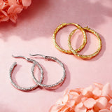 These S925 sterling silver hoop earrings feature a textured, molten lava-like finish in a warm gold tone. The organic, uneven surface creates a rugged, handcrafted appearance, while the classic oval hoop shape adds a timeless, elegant touch to the design. The secure post-back closure ensures comfortable all-day wear.