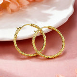These S925 sterling silver hoop earrings feature a textured, molten lava-like finish in a warm gold tone. The organic, uneven surface creates a rugged, handcrafted appearance, while the classic oval hoop shape adds a timeless, elegant touch to the design. The secure post-back closure ensures comfortable all-day wear.