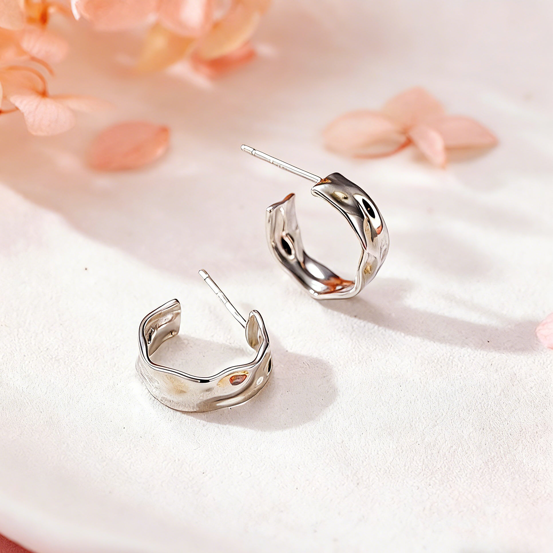 These sterling silver stud earrings are inspired by the natural, smooth folds of tin foil. Their surface texture resembles the wrinkles on tin foil, presenting a stunning sheen. The simple yet stylish design makes them versatile and practical, easily adding a touch of modern fashion to your everyday outfits.