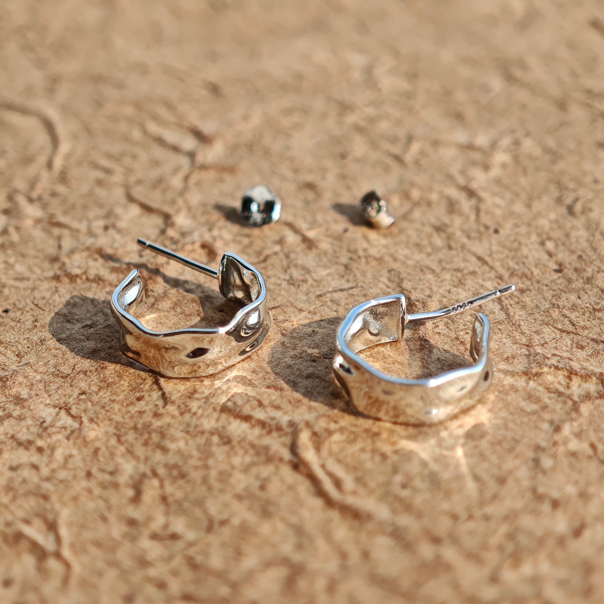 These sterling silver stud earrings are inspired by the natural, smooth folds of tin foil. Their surface texture resembles the wrinkles on tin foil, presenting a stunning sheen. The simple yet stylish design makes them versatile and practical, easily adding a touch of modern fashion to your everyday outfits.