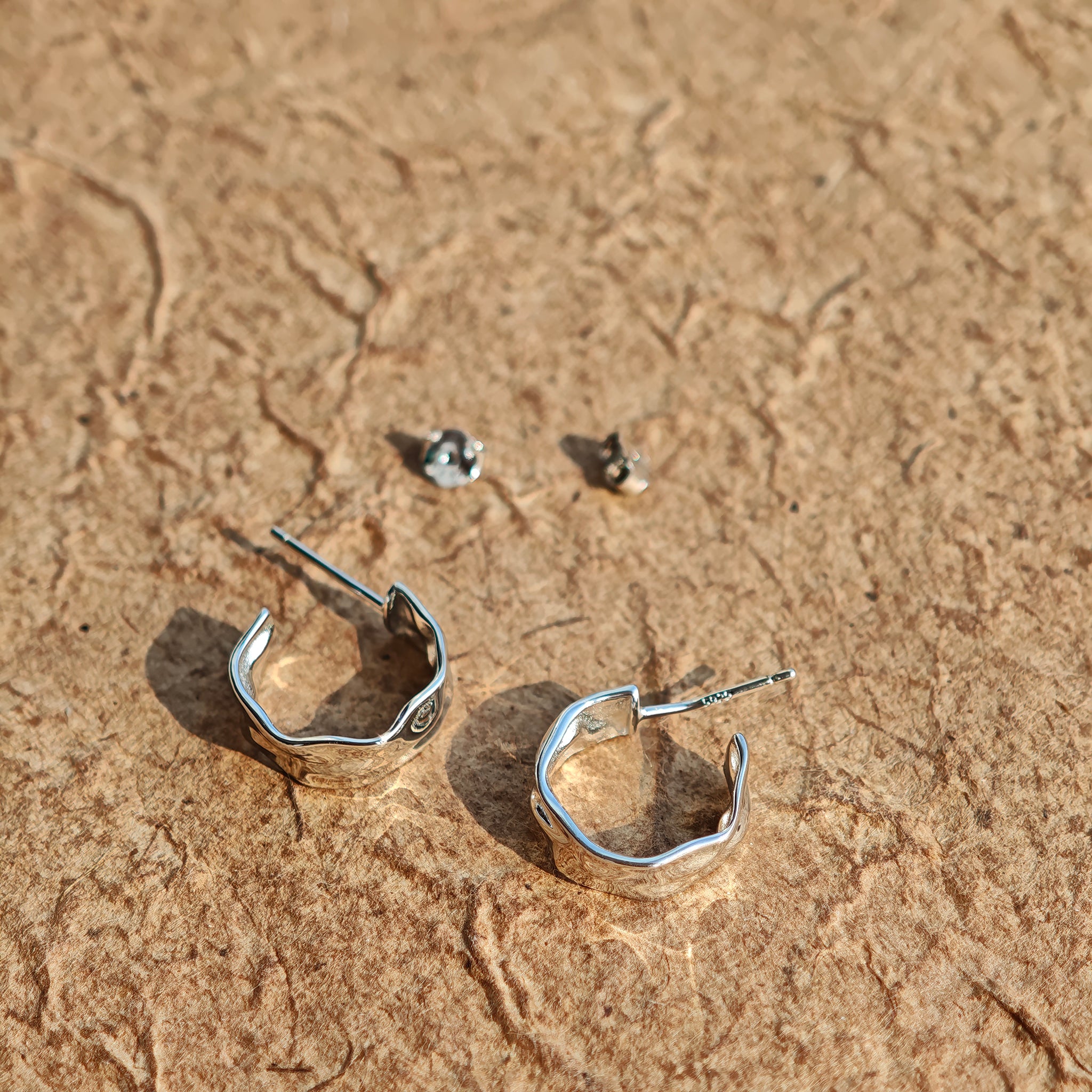 These sterling silver stud earrings are inspired by the natural, smooth folds of tin foil. Their surface texture resembles the wrinkles on tin foil, presenting a stunning sheen. The simple yet stylish design makes them versatile and practical, easily adding a touch of modern fashion to your everyday outfits.