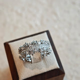 This snowflake zircon open ring features an intricate and textured band, adorned with clusters of sparkling zircon stones that mimic delicate snowflakes. Its adjustable open design ensures a comfortable fit, while the polished copper alloy metal reflects light beautifully, creating an elegant, frosty aesthetic. The detailed craftsmanship gives it a luxurious, eye-catching appearance ideal for adding a wintry charm to any look.