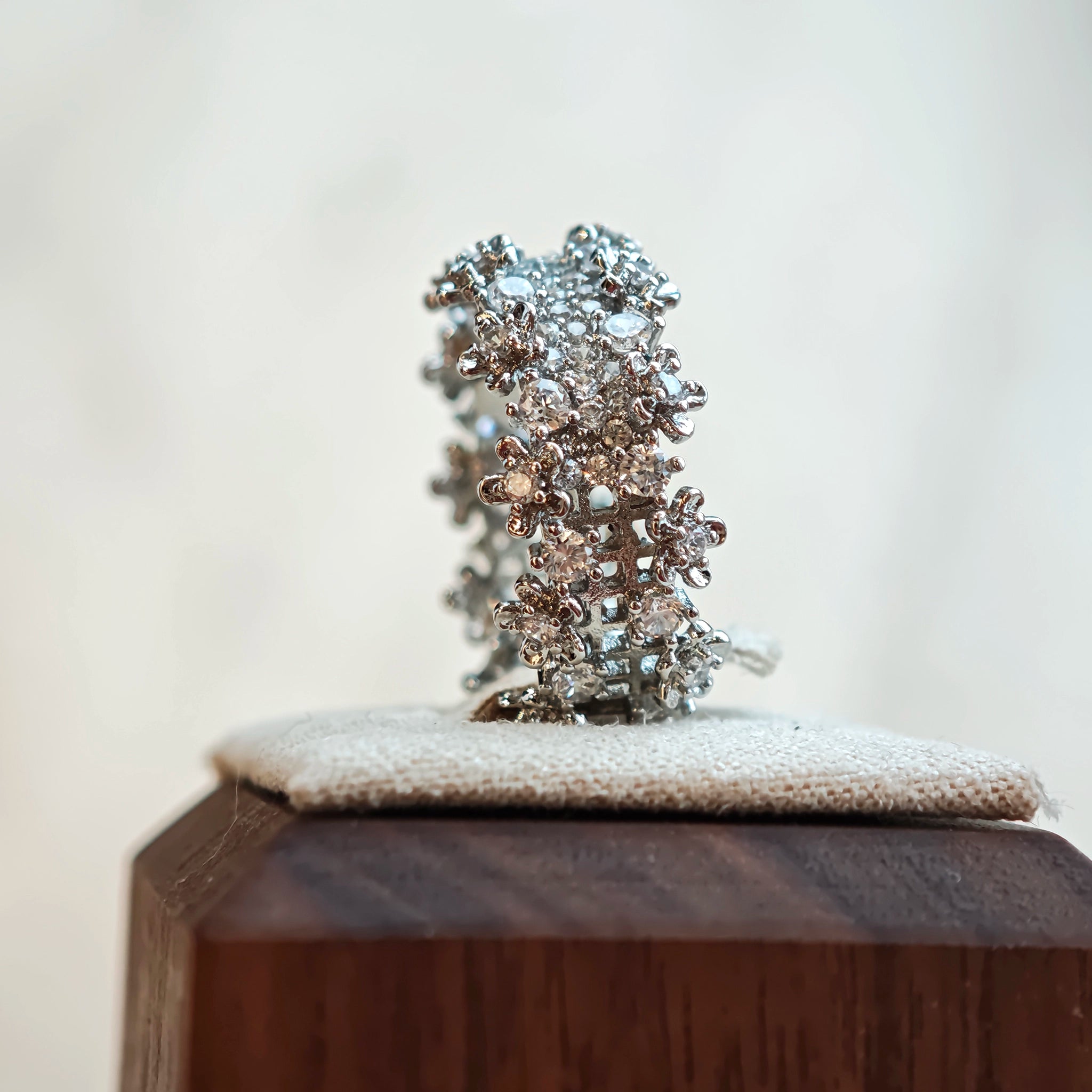 This snowflake zircon open ring features an intricate and textured band, adorned with clusters of sparkling zircon stones that mimic delicate snowflakes. Its adjustable open design ensures a comfortable fit, while the polished copper alloy metal reflects light beautifully, creating an elegant, frosty aesthetic. The detailed craftsmanship gives it a luxurious, eye-catching appearance ideal for adding a wintry charm to any look.