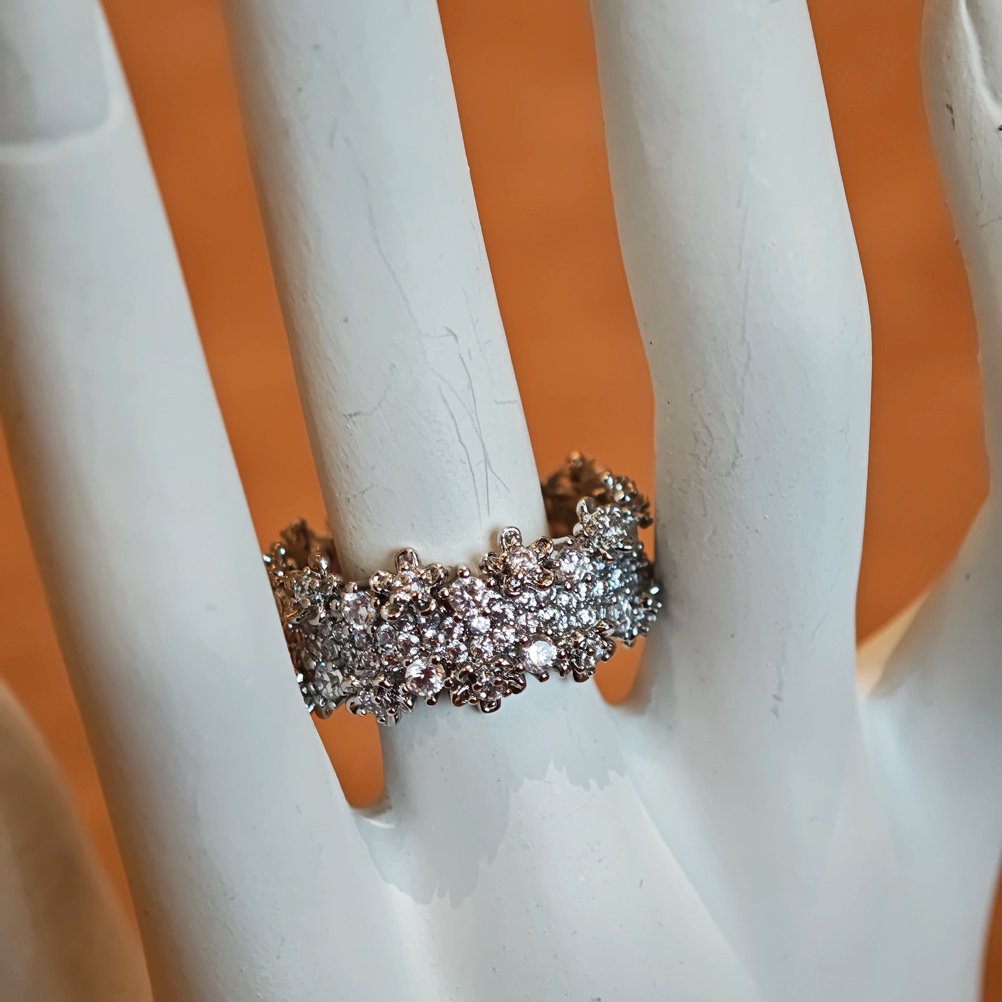 This snowflake zircon open ring features an intricate and textured band, adorned with clusters of sparkling zircon stones that mimic delicate snowflakes. Its adjustable open design ensures a comfortable fit, while the polished copper alloy metal reflects light beautifully, creating an elegant, frosty aesthetic. The detailed craftsmanship gives it a luxurious, eye-catching appearance ideal for adding a wintry charm to any look.