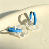 These summer candy-colored hoop earrings feature cute carved natural stone flower pendants paired with glossy enamel-coated metal hoops. They come in a vibrant palette of playful bright hues, creating a fresh, sweet and youthful summery style. The minimalist huggie hoop structure with delicate floral charms makes them lightweight and versatile for daily casual wear.