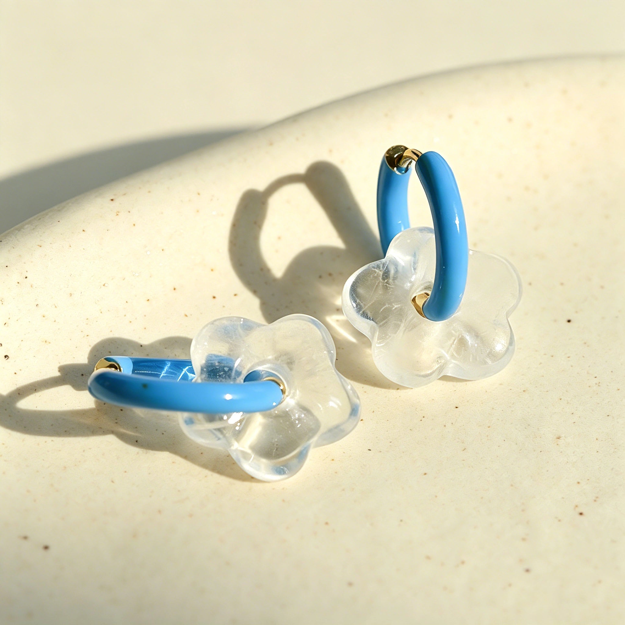 These summer candy-colored hoop earrings feature cute carved natural stone flower pendants paired with glossy enamel-coated metal hoops. They come in a vibrant palette of playful bright hues, creating a fresh, sweet and youthful summery style. The minimalist huggie hoop structure with delicate floral charms makes them lightweight and versatile for daily casual wear.