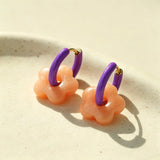 These summer candy-colored hoop earrings feature cute carved natural stone flower pendants paired with glossy enamel-coated metal hoops. They come in a vibrant palette of playful bright hues, creating a fresh, sweet and youthful summery style. The minimalist huggie hoop structure with delicate floral charms makes them lightweight and versatile for daily casual wear.