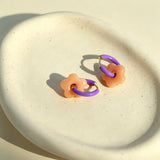 These summer candy-colored hoop earrings feature cute carved natural stone flower pendants paired with glossy enamel-coated metal hoops. They come in a vibrant palette of playful bright hues, creating a fresh, sweet and youthful summery style. The minimalist huggie hoop structure with delicate floral charms makes them lightweight and versatile for daily casual wear.