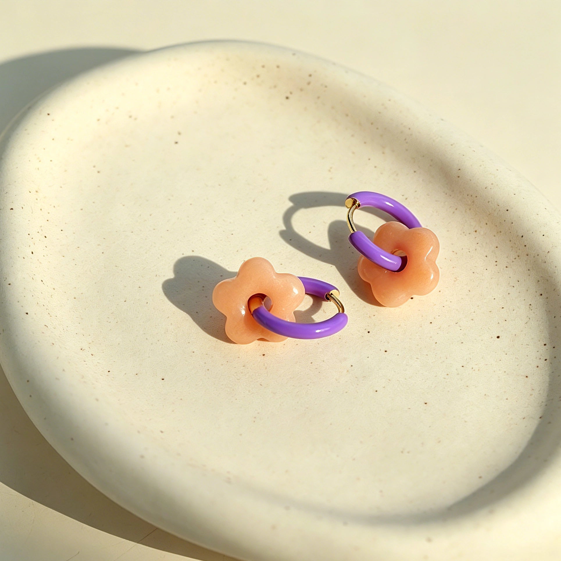 These summer candy-colored hoop earrings feature cute carved natural stone flower pendants paired with glossy enamel-coated metal hoops. They come in a vibrant palette of playful bright hues, creating a fresh, sweet and youthful summery style. The minimalist huggie hoop structure with delicate floral charms makes them lightweight and versatile for daily casual wear.