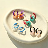 These summer candy-colored hoop earrings feature cute carved natural stone flower pendants paired with glossy enamel-coated metal hoops. They come in a vibrant palette of playful bright hues, creating a fresh, sweet and youthful summery style. The minimalist huggie hoop structure with delicate floral charms makes them lightweight and versatile for daily casual wear.
