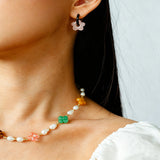 These summer candy-colored hoop earrings feature cute carved natural stone flower pendants paired with glossy enamel-coated metal hoops. They come in a vibrant palette of playful bright hues, creating a fresh, sweet and youthful summery style. The minimalist huggie hoop structure with delicate floral charms makes them lightweight and versatile for daily casual wear.