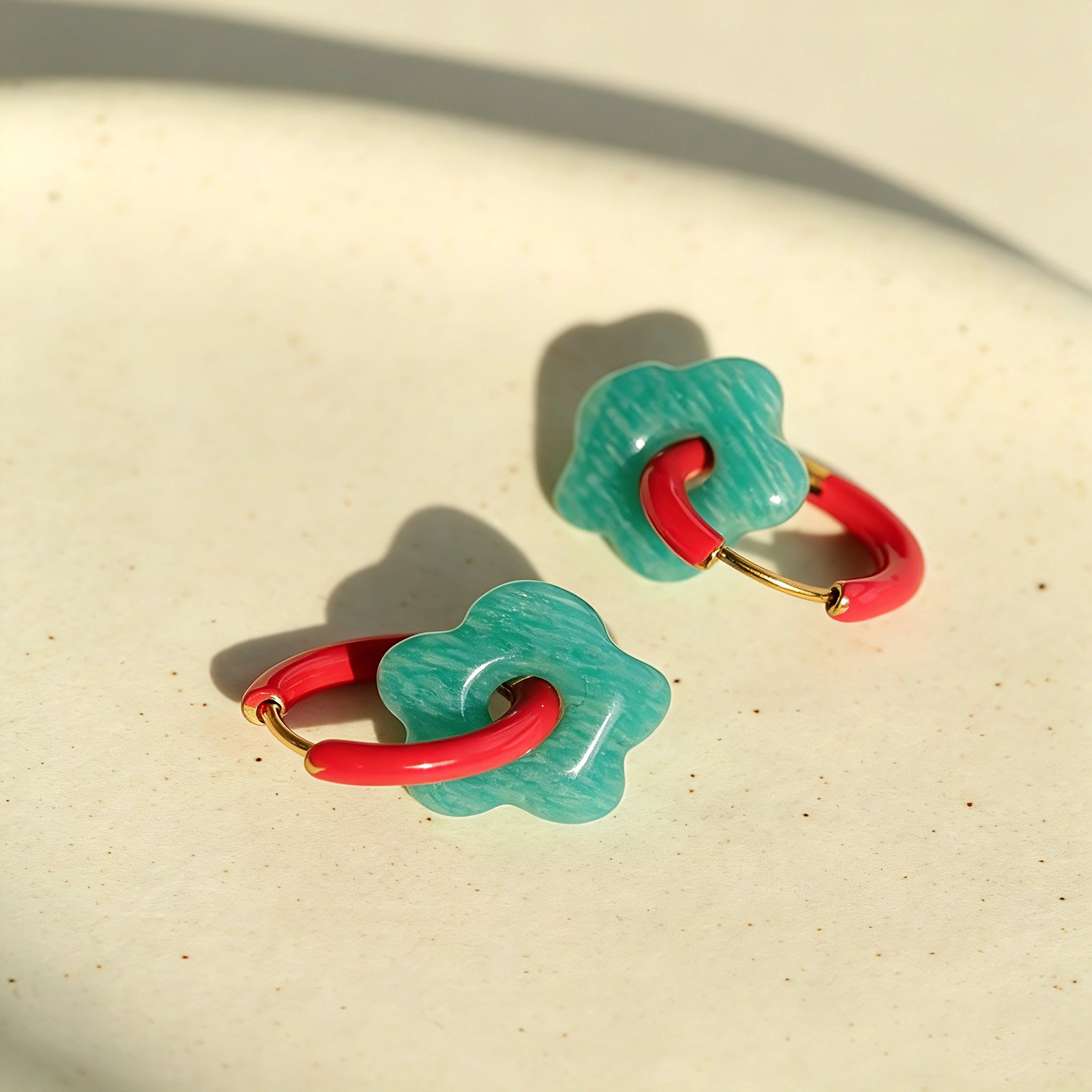 These summer candy-colored hoop earrings feature cute carved natural stone flower pendants paired with glossy enamel-coated metal hoops. They come in a vibrant palette of playful bright hues, creating a fresh, sweet and youthful summery style. The minimalist huggie hoop structure with delicate floral charms makes them lightweight and versatile for daily casual wear.