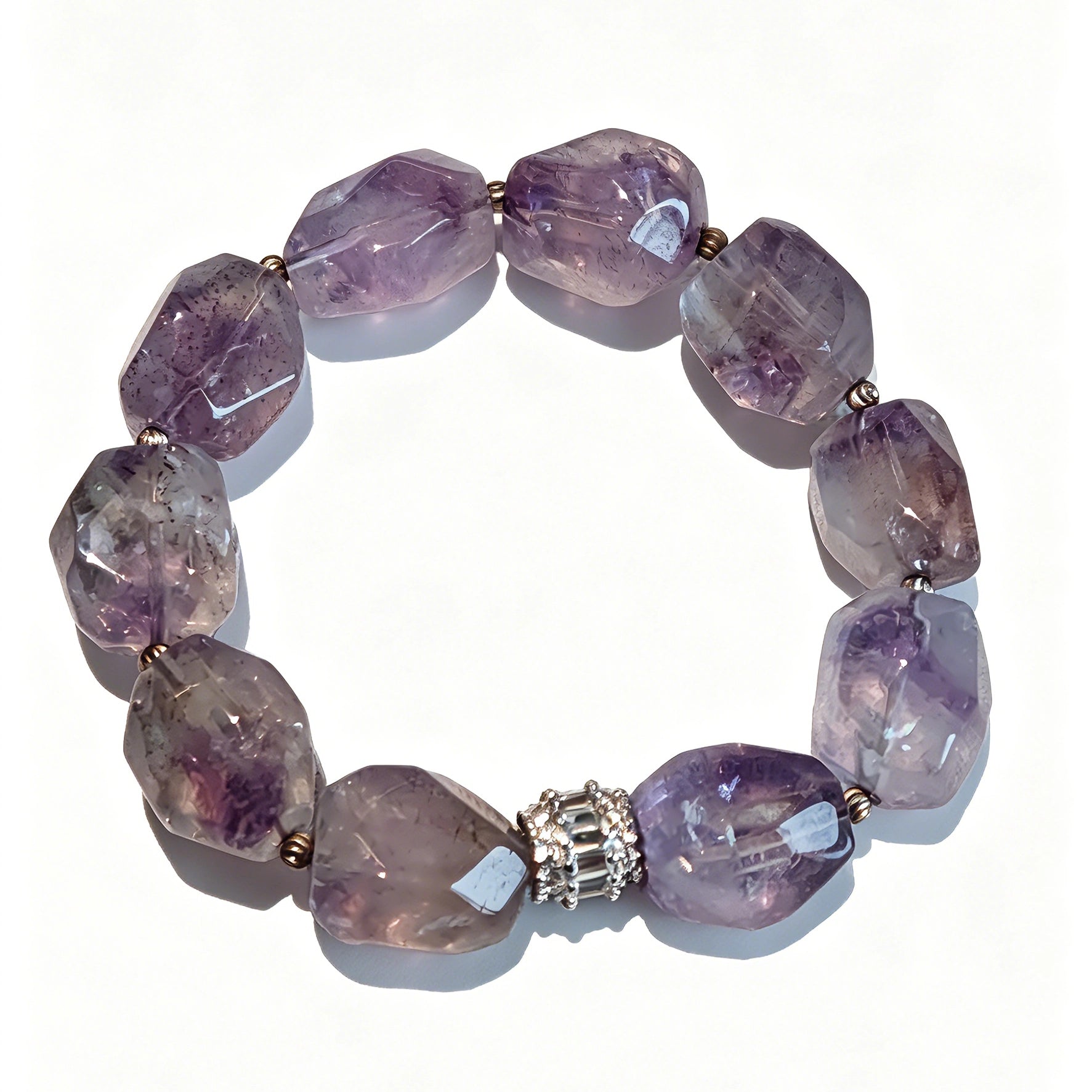 This exquisite Super Seven bracelet showcases irregularly faceted beads in a captivating blend of soft lavender and smoky purple hues, each displaying unique natural inclusions that catch the light beautifully. The polished crystals are seamlessly interspersed with tiny metallic spacer beads, culminating in an ornate silver-tone decorative bead that adds a touch of elegance to the organic design. Crafted with meticulous attention to detail, the bracelet offers a harmonious blend of rare gemstone texture and