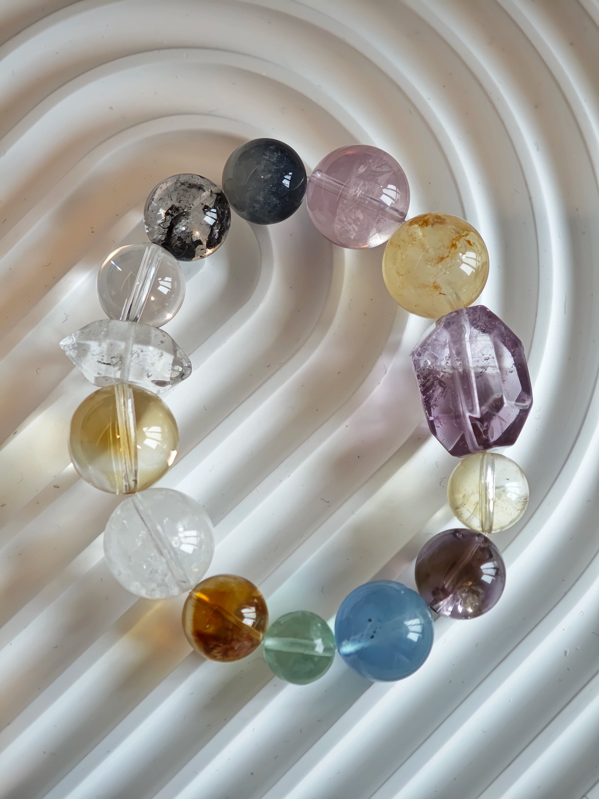 This is a rainbow energy bracelet that consists of Aquamarine, Amethyst, Clear Quartz, White Phantom Quartz, Citrine, Prehnite, Golden Healer, and Herkimer Diamond.