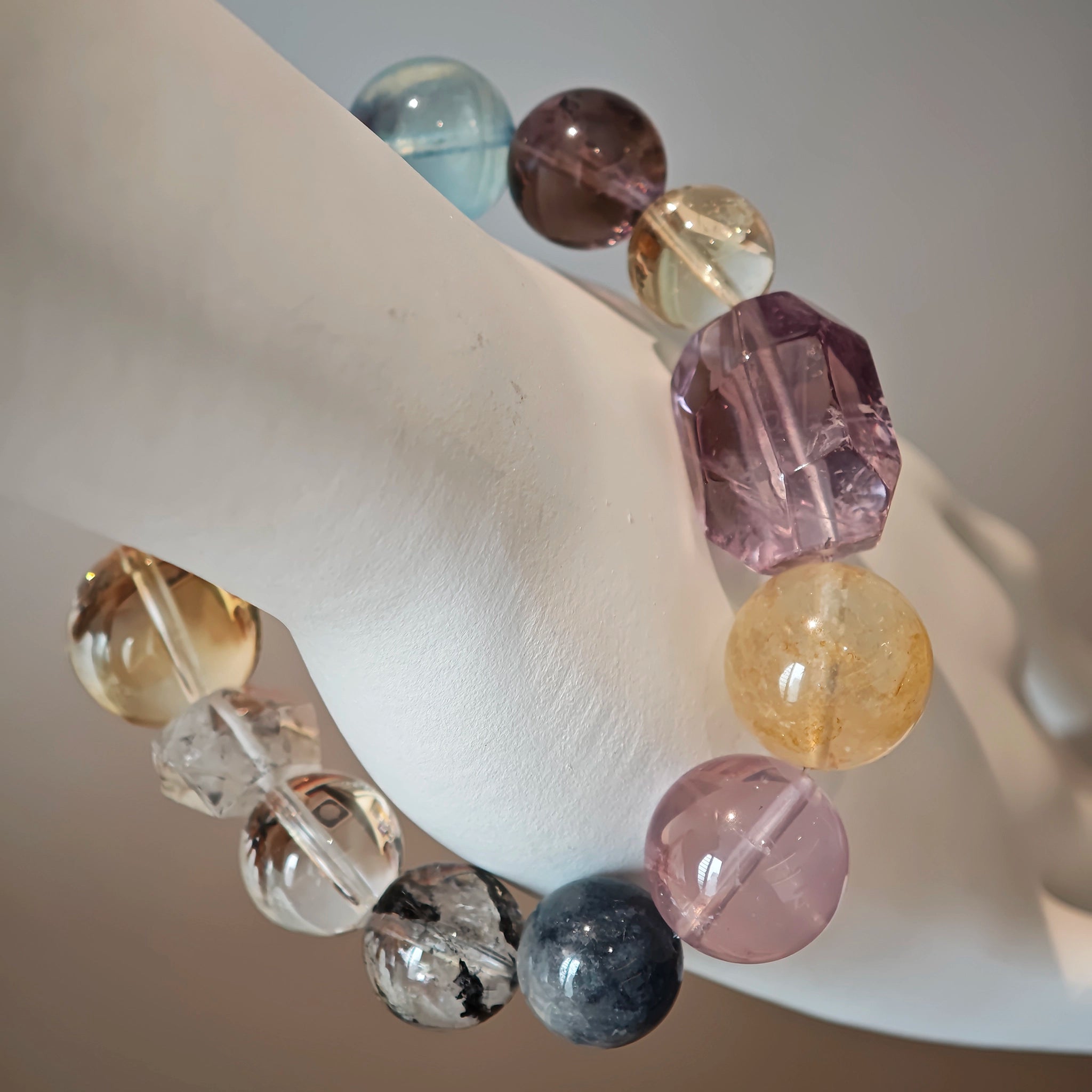 This is a rainbow energy bracelet that consists of Aquamarine, Amethyst, Clear Quartz, White Phantom Quartz, Citrine, Prehnite, Golden Healer, and Herkimer Diamond.