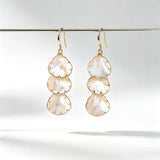 These drop earrings feature three layered natural shell slices with iridescent pearlescent luster. Each shell piece is framed by delicate gold‑tone metal trim for a vintage elegant look. The hook design offers comfortable wear for everyday and special occasions.