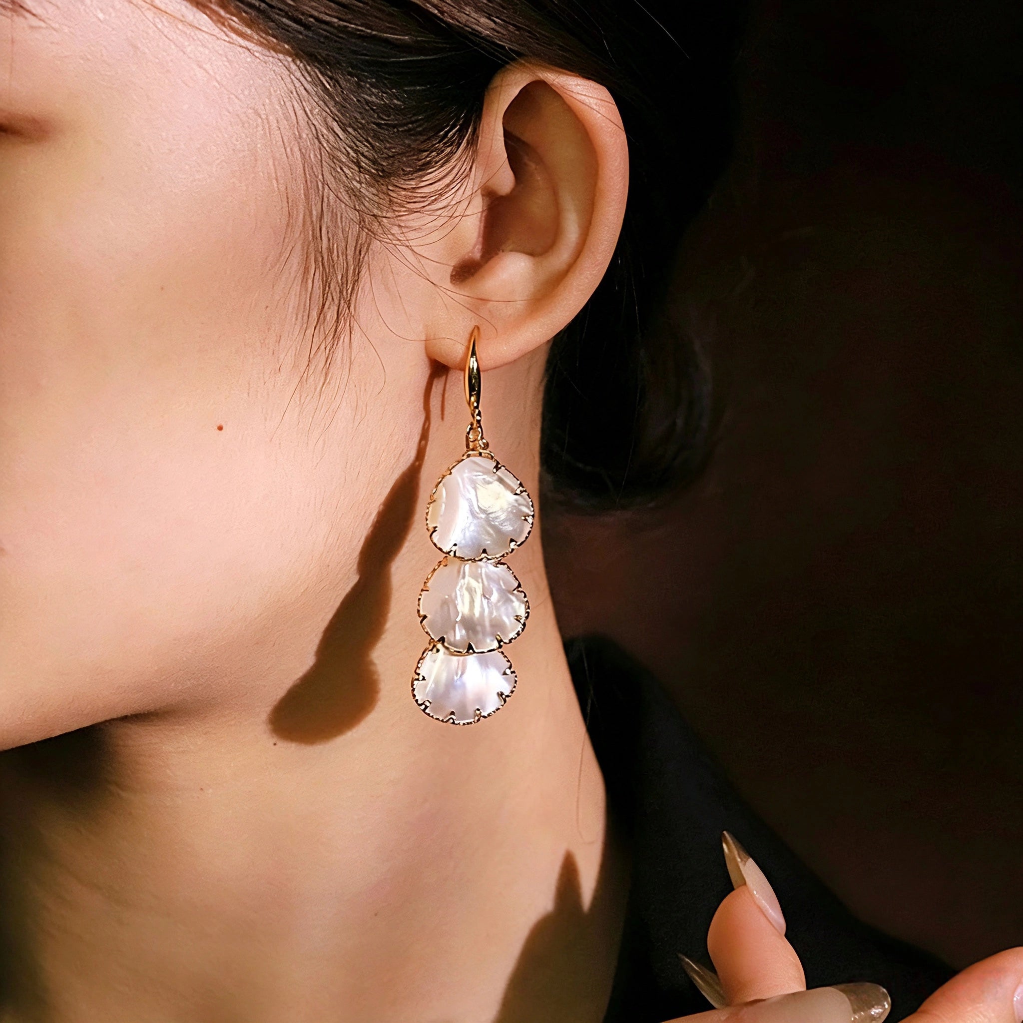 These drop earrings feature three layered natural shell slices with iridescent pearlescent luster. Each shell piece is framed by delicate gold‑tone metal trim for a vintage elegant look. The hook design offers comfortable wear for everyday and special occasions.
