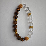 This is a tiger's eye bracelet with clear quartz and gold-plated copper spacer.