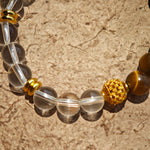 This is a tiger's eye bracelet with clear quartz and gold-plated copper spacer.