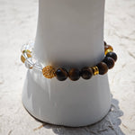 This is a tiger's eye bracelet with clear quartz and gold-plated copper spacer.