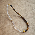 This is a necklace with tiger's eye, clear quartz, gold-plated spacer and elastic cord.
