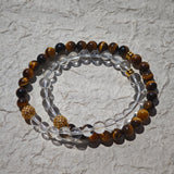 This is a necklace with tiger's eye, clear quartz, gold-plated spacer and elastic cord.